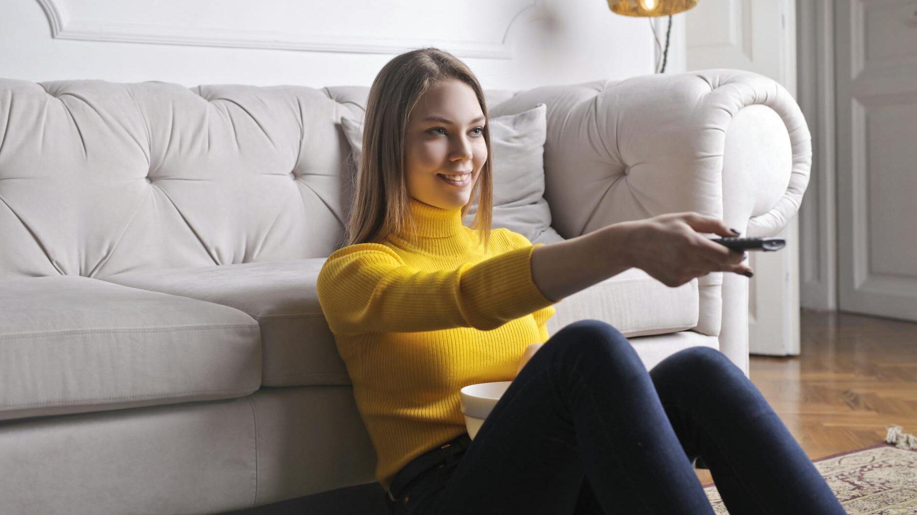 happy young relaxed woman watching tv at home